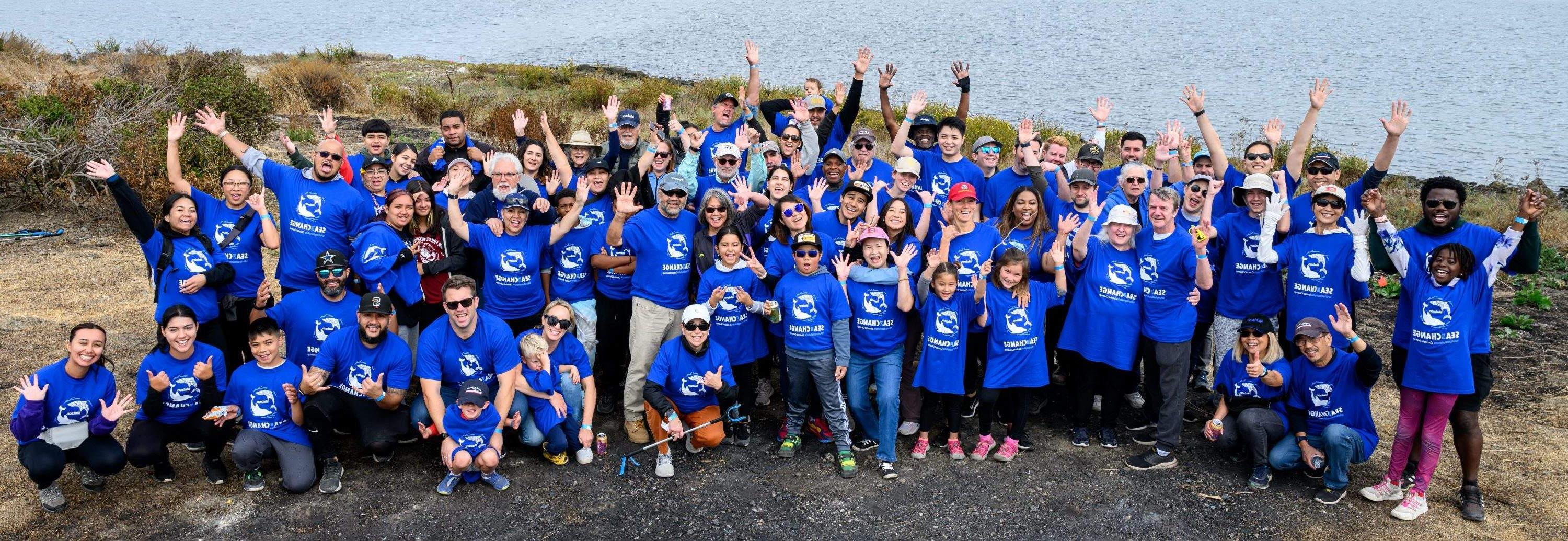 Group picture of 澳博体育app下载 volunteers wearing blue "Sea The Change" t-shirts at the Oakland Estuary.